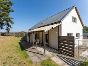 a white farmhouse with a fence and a gate at Holiday Home Muir Edge by Interhome in Nethy Bridge