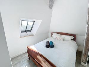 a bedroom with a bed with two shoes on it at Le Giuseppe - Nid central in Compiègne +13 photos