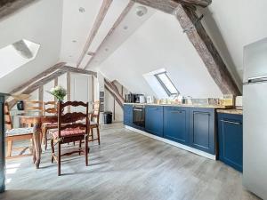 a kitchen with blue cabinets and a wooden table at Le Giuseppe - Nid central in Compiègne