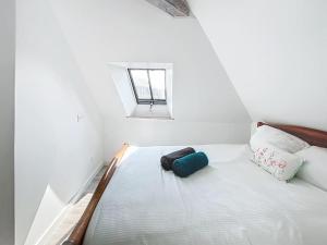 a bed in a white room with a window at Le Giuseppe - Nid central in Compiègne