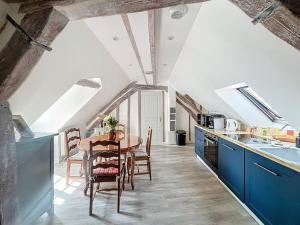 a kitchen with a table and a kitchen with blue cabinets at Le Giuseppe - Nid central in Compiègne