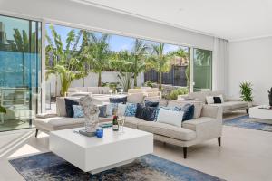 ein Wohnzimmer mit Sofas und einem Tisch in der Unterkunft KARAT Villa Splendida in Playa Paraiso