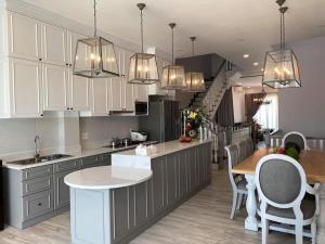 a kitchen with white cabinets and a table and a counter at Homestay Ocean Real in Phan Thiet