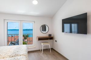ein Schlafzimmer mit einem Bett, einem Fernseher und einem Fenster in der Unterkunft The View in Crikvenica