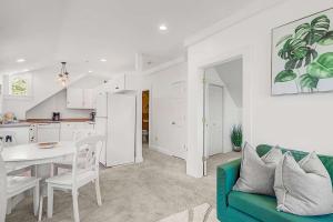 Una sala de estar con un sofá verde y una cocina. en Oasis on Commercial Street w Balcony, en Provincetown