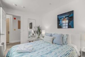 Dormitorio blanco con cama con edredón azul en Oasis on Commercial Street w Balcony, en Provincetown