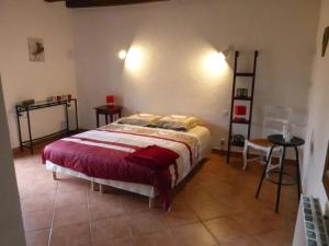 ein Schlafzimmer mit einem Bett mit einer roten Decke in der Unterkunft Villa charmante dans les vergers de Normandie avec piscine privée. in Épinay