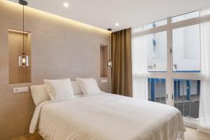 a bedroom with a large white bed and a window at Luxury Loft Mar y Sol 2 in Tacoronte