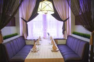 ペレスラヴリ・ザレスキーにあるOskarの紫色のソファと窓の前のテーブルが備わる客室です。