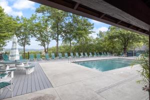 ein Swimmingpool mit Liegestühlen und einem Tisch in der Unterkunft Paradise Lookout Margaritaville - Views and Pools in Osage Beach