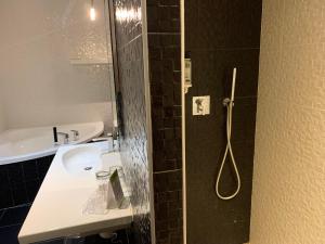 a bathroom with a sink and a shower with a shower at Les Criquets Hôtel & Spa in Blanquefort