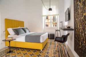 ローマにあるBelli 36 Roomsのベッドルーム1室(ベッド1台、テーブル、椅子付)