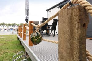 a wooden deck with a rope tied to a pole at Ferienwohnung Hafenhus in Peenemünde