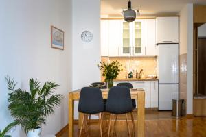 a kitchen with a table with chairs and a refrigerator at Apartman Ivice in Gornji Milanovac