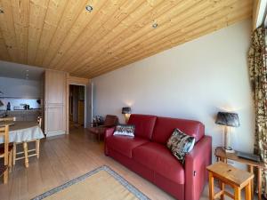 un salon avec un canapé rouge et une table dans l'établissement Homency Résidence Signal B16, à L'Alpe-d'Huez 12 autres photos