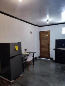 ゼネラル・ルナにあるMoonstone Suitesのキッチン(テーブル、黒い冷蔵庫付)