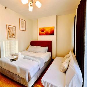 a bedroom with two beds in a room at Cozy Studio with Balcony in Mesaverte near SM Downtown 4pax max with Free Pool & Netflix in Cagayan de Oro +11 photos