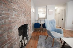 a living room with a brick fireplace and a blue chair at Fashionable 1-Bedrm Apt 15 Min to Manhattan in Hoboken