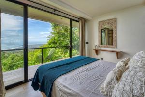a bedroom with a bed and a large window at Bali Villa Jungle Paradise - Uvita in Uvita