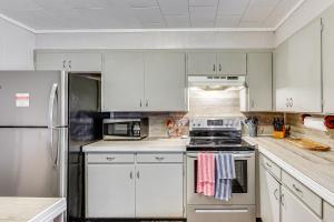 a kitchen with white cabinets and stainless steel appliances at Rural Escape Near Lake Ouachita with Gas Grill! in Pearcy