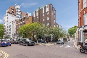 a city street with cars parked on the side of the road at Modern and Airy Belgravia Living in London