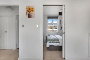 a white bedroom with a bed and a mirror at Modern and Airy Belgravia Living in London