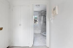 a white bathroom with a shower and a toilet at Modern and Airy Belgravia Living in London