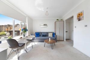 a living room with a blue couch and a table at Modern and Airy Belgravia Living in London