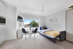 a bedroom with a bed and a table and chairs at Modern and Airy Belgravia Living in London