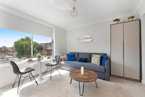 a living room with a couch and a table and chairs at Modern and Airy Belgravia Living in London