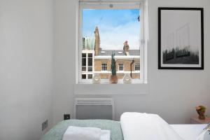 a bedroom with a window with a view of a building at Modern and Airy Belgravia Living in London