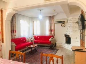 a living room with red couches and a fireplace at Villa Truva in Fethiye
