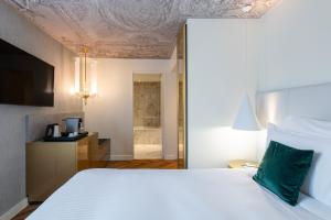 Un ou plusieurs lits dans un hébergement de l'établissement Le Louis Hotel Versailles Château - MGallery Collection