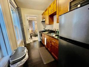 a kitchen with a stainless steel refrigerator and wooden cabinets at Beautiful 3BR 3BA Duplex parking Best Location Boston in Boston
