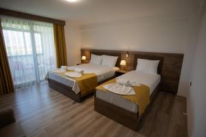 a hotel room with two beds and a window at E87 Highway Otel in Burhaniye
