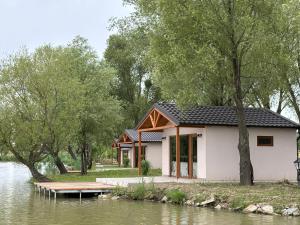 a building next to a body of water at Bene- hegyi apartmanok in Csepreg