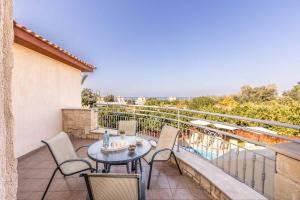 un patio avec une table et des chaises sur un balcon dans l'établissement Stavros Villa, à Pólis Chrysochoús