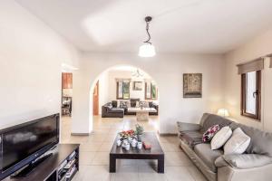 un salon avec un canapé et une télévision dans l'établissement Stavros Villa, à Pólis Chrysochoús