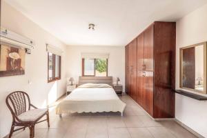 une chambre avec un lit et une chaise dedans dans l'établissement Stavros Villa, à Pólis Chrysochoús 25 autres photos