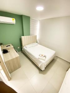 a small room with a bed and a table at Hotel Boutique Betania in Valledupar