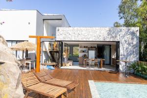 ein Haus mit einem Pool und einer Terrasse mit Bänken in der Unterkunft Casa LUXO c/ vista panorâmica em Vila Velha-SH095D in Convento da Penha