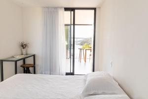 ein weißes Schlafzimmer mit Bett und Balkon in der Unterkunft Casa LUXO c/ vista panorâmica em Vila Velha-SH095D in Convento da Penha