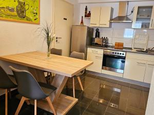 a kitchen with a wooden table and chairs in it at Gästeappartement Viktoria in Sinsheim