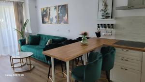 a living room with a green couch and a table at Odiseea Apartment-Private parking included in Sibiu
