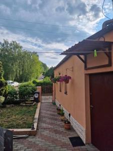 a brick walkway next to a house with flowers on it at Pod Brzózką in Gdynia