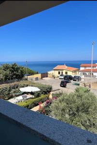 a balcony with a view of a parking lot and the ocean at Appartamento Casa Vittoria - La Ciaccia in La Ciaccia
