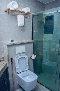 a bathroom with a toilet and a glass shower at Grand Palmac Hotel in Abuja +22 photos