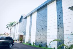 a car parked in front of a building at Grand Palmac Hotel in Abuja