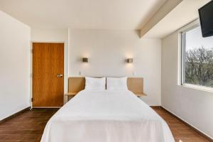 a bedroom with a large white bed and a window at One Salina Cruz in Salina Cruz +55 photos