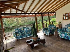a porch with two chairs and a potted plant at Villa carmelita in Jardin